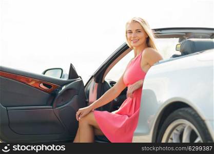 travel, road trip and people concept - happy young woman posing in convertible car. happy young woman porisng in convertible car