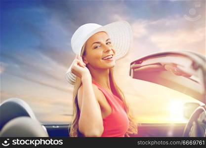 travel, road trip and people concept - happy young woman wearing sun hat in convertible car over sunset sky background. happy young woman in convertible car. happy young woman in convertible car
