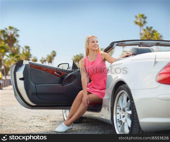 travel, road trip and summer holidays concept - happy young woman posing in convertible car over venice beach background in california. woman posing in convertible car over venice beach. woman posing in convertible car over venice beach