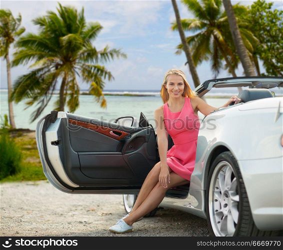 travel, road trip and summer holidays concept - happy young woman posing in convertible car over exotic beach with palm trees in french polynesia background. happy young woman in convertible car over beach. happy young woman in convertible car over beach
