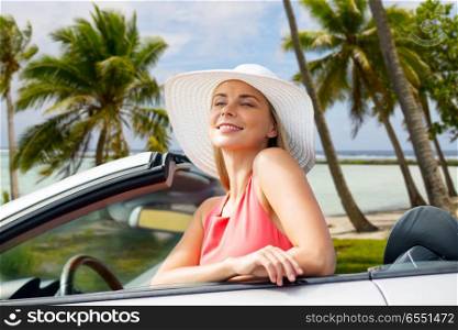 travel, road trip and summer holidays concept - happy young woman wearing sun hat in convertible car over exotic beach with palm trees in french polynesia background. happy young woman in convertible car over beach. happy young woman in convertible car over beach