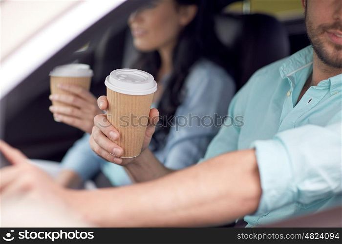 travel, road trip, drinks and people concept - close up of couple driving in car with coffee cups