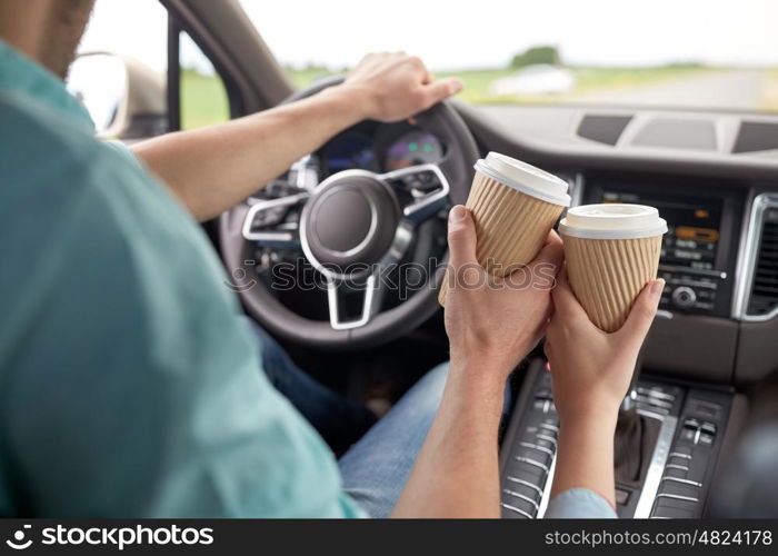 travel, road trip, drinks and people concept - close up of couple driving in car with coffee cups