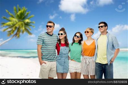 travel, summer holidays and tourism concept - group of happy smiling friends in sunglasses hugging over tropical beach background in french polynesia. friends in sunglasses over tropical beach