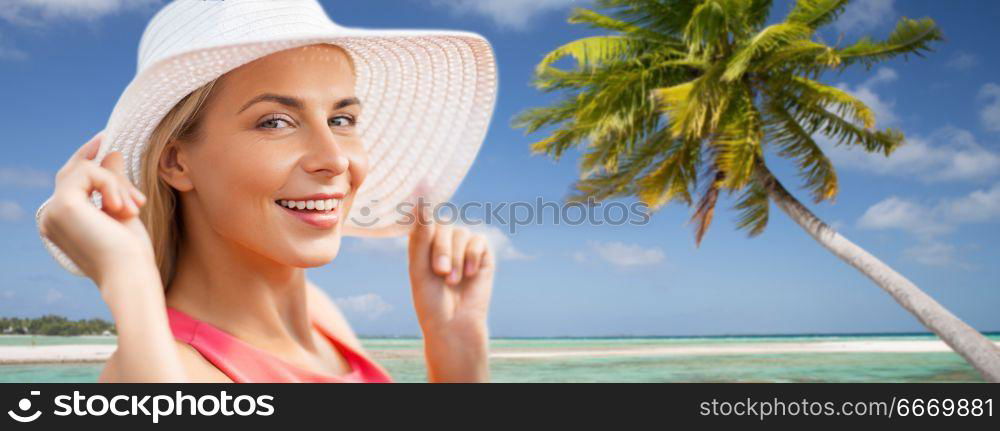 travel, summer holidays and tourism concept - portrait of beautiful smiling woman in sun hat over exotic tropical beach with palm trees background. portrait of smiling woman in sun hat over beach. portrait of smiling woman in sun hat over beach