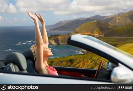 travel, summer holidays, road trip and people concept - happy young woman in convertible car enjoying sun over bixby creek bridge on big sur coast of california background. happy woman in convertible car on big sur coast. happy woman in convertible car on big sur coast
