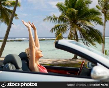 travel, summer holidays, road trip and people concept - happy young woman in convertible car enjoying sun over tropical beach background in french polynesia. happy young woman in convertible car over beach. happy young woman in convertible car over beach