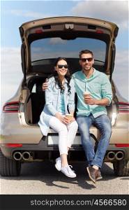 travel, summer vacation, road trip, leisure and people concept - happy couple drinking coffee from disposable cups sitting on trunk of hatchback car outdoors
