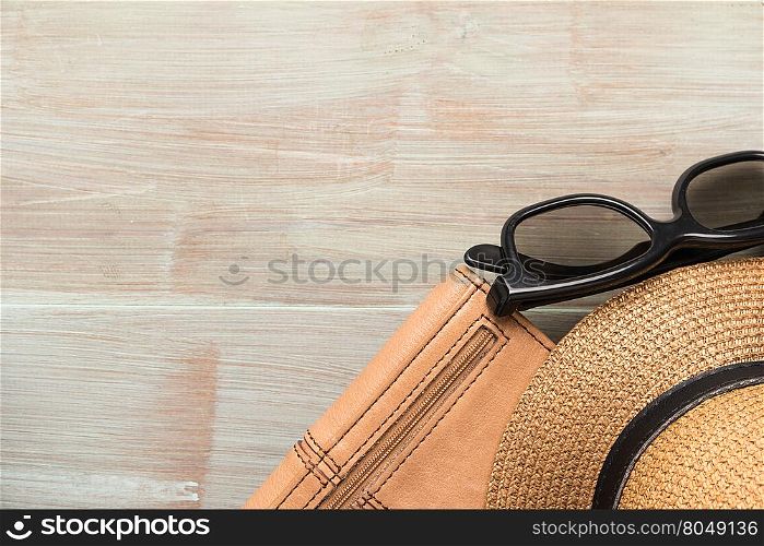 Travel, summer vacation, tourism and objects concept - close up of hat, wallet, sunglasses and scarf on wooden table. Top view with copy space.