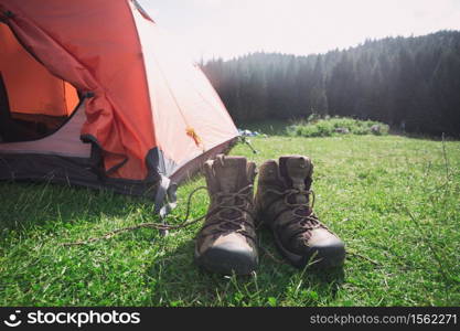 travel. the tourist goes on a hike through the mountains - a tent and boots