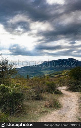 travel to Crimea - dark gray clouds over mountan valley near The Valley of Ghosts on Crimean Southern Coast