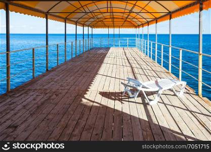 travel to Crimea - one plastic lounge in outdoor solarium over Black Sea on embankment in Professors Corner district in Alushta city