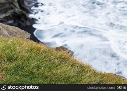 travel to Iceland - green grass on edge of cliff near Vik I Myrdal village on Atlantic South Coast in Katla Geopark in september