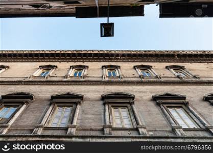 travel to Italy - bottom view of dark facades of old houses on narrow street ( Via dei Farnesi) in Rome city