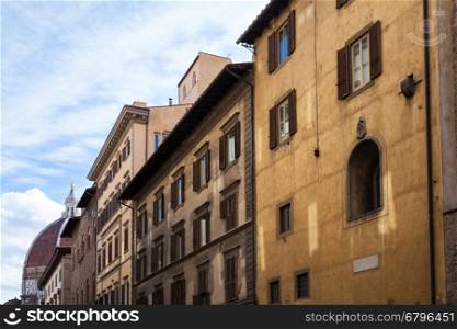 travel to Italy - old apartment buildings and dome of Cathedral on street in historic centre of Florence city