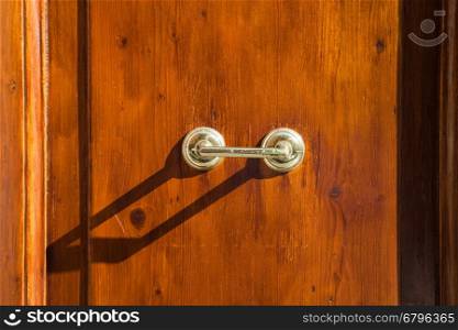 travel to Italy - old external brass door handle on brown wooden door in Rome city
