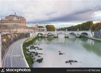 travel to Italy - waterfront of Tiber River, Castel Sant Angelo (Castle of the Holy Angel, Mausoleum of Hadrian) and bridge of St Angel in Rome city in autumn evening twilight