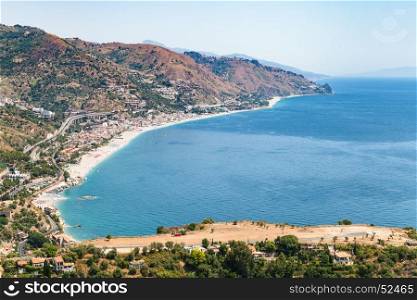 travel to Sicily, Italy - above view of Letojanni resort village of beach of Ionian Sea from Taormina city in summer day
