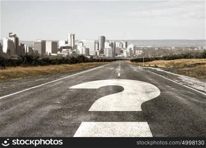 Travel to unknown destination. Cityscape and question mark drawn on asphalt road