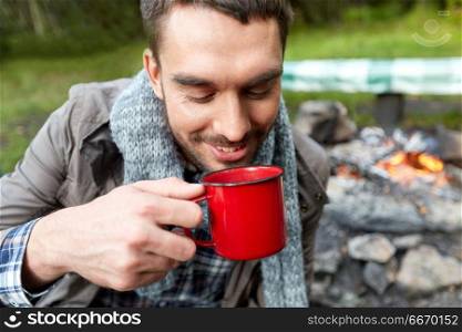 travel, tourism and camping concept - close up of smiling man drinking from cup at camp. close up of smiling man drinking from cup at camp. close up of smiling man drinking from cup at camp