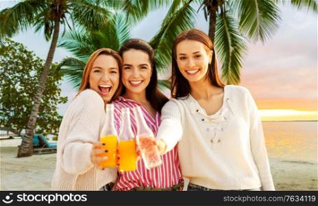 travel, tourism and friendship concept - group of happy young women or female friends toasting non alcoholic drinks over tropical beach background in french polynesia. young women toasting non alcoholic drinks on beach