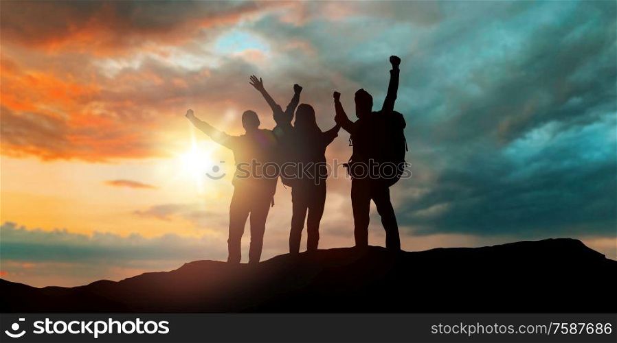 travel, tourism and hike concept - group of travellers with backpacks over sunset background. group of travellers with backpacks over sunset