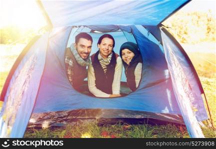 travel, tourism and hike concept - happy family in tent at camp site. happy family in tent at camp site