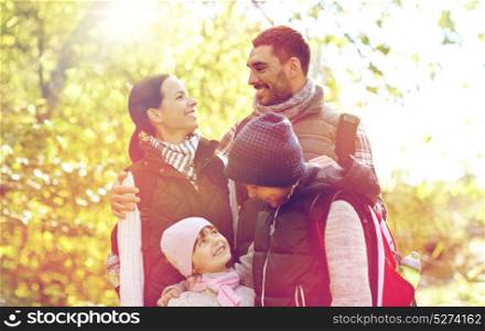 travel, tourism and hike concept - happy family walking with backpacks outdoors. happy family with backpacks hiking