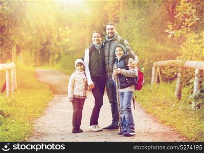travel, tourism and hike concept - happy family walking with backpacks outdoors. happy family with backpacks hiking