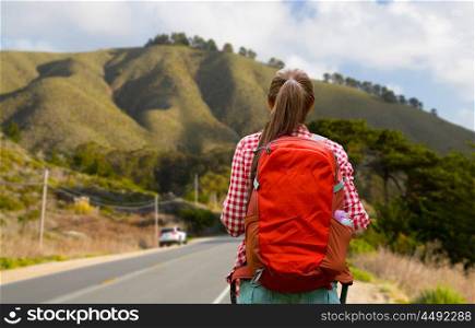travel, tourism and hike concept - young woman with backpack over big sur of california hills background. woman with backpack traveling over big sur hills. woman with backpack traveling over big sur hills
