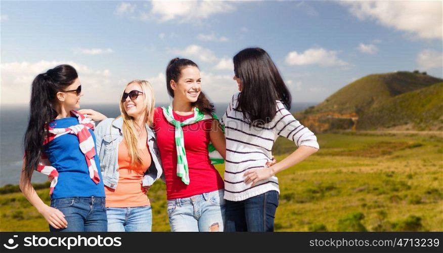 travel, tourism and people concept - beautiful teenage girls or young women over big sur coast of california background. teenage girls or young women over big sur coast. teenage girls or young women over big sur coast