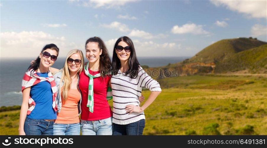 travel, tourism and people concept - beautiful teenage girls or young women over big sur coast of california background. teenage girls or young women over big sur coast. teenage girls or young women over big sur coast