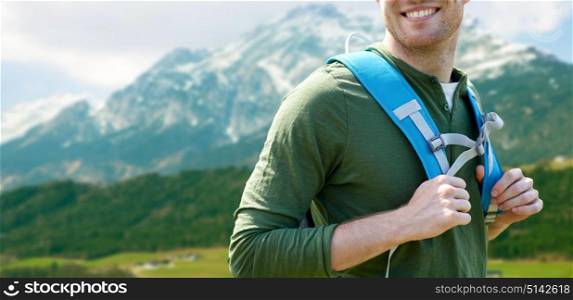 travel, tourism and people concept - close up of happy young man with backpack over alps mountains background. close up of happy man with backpack traveling
