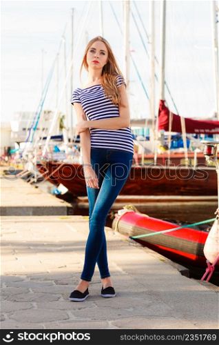 Travel tourism and people concept. Fashion blonde girl in marina against yachts in port