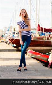 Travel tourism and people concept. Fashion blonde girl in marina against yachts in port
