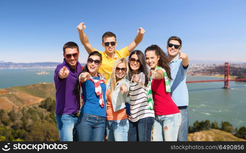 travel, tourism and people concept - group of happy friends pointing at you over golden gate bridge in san francisco bay background. group of happy friends over golden gate bridge. group of happy friends over golden gate bridge
