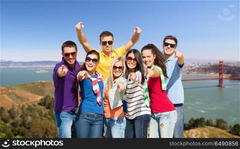 travel, tourism and people concept - group of happy friends pointing at you over golden gate bridge in san francisco bay background. group of happy friends over golden gate bridge. group of happy friends over golden gate bridge