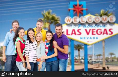 travel, tourism and people concept - group of happy friends pointing at you over welcome to fabulous las vegas sign background. happy friends over welcome to las vegas sign. happy friends over welcome to las vegas sign