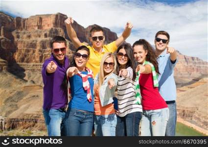 travel, tourism and people concept - group of happy friends pointing at you over grand canyon national park background. happy friends pointing at you over grand canyon. happy friends pointing at you over grand canyon