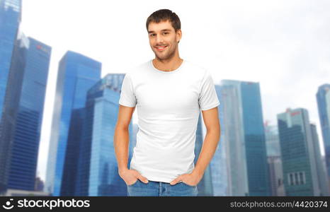 travel, tourism and people concept - handsome man in blank white t-shirt over singapore city skyscrapers background