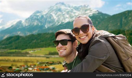 travel, tourism and people concept - happy couple in sunglasses with backpacks traveling over mountains background. happy couple with backpacks traveling in highlands