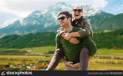 travel, tourism and people concept - happy couple with backpacks having fun over alps mountains background. happy couple with backpacks traveling in highlands