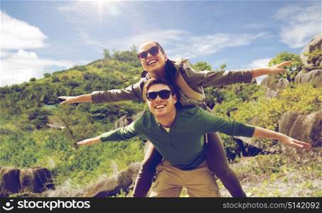 travel, tourism and people concept - happy couple with backpacks having fun over natural background. happy couple with backpacks having fun outdoors