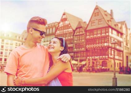 travel, tourism and people concept - happy smiling teenage couple hugging and looking at each other over frankfurt am main city background. happy teenage coupler in frankfurt city