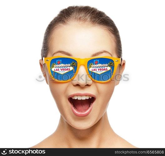 travel, tourism and people concept - portrait of happy amazed woman or teenage girl in sunglasses with welcome to fabulous las vegas sign reflection. woman in sunglasses with las vegas sign reflection