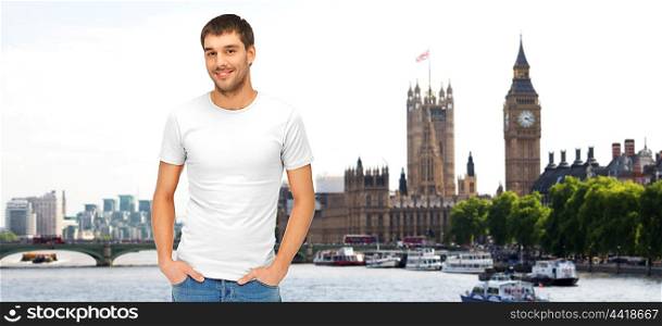 travel, tourism and people concept - smiling man in blank white t-shirt over london city background