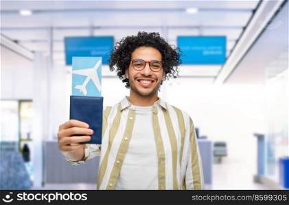 travel, tourism and people concept - smiling man with passport and air ticket over airport background. happy man with passport and air ticket at airport