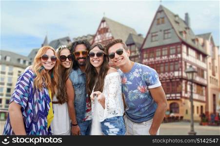 travel, tourism and people concept - smiling young hippie friends taking selfie by monopod over frankfurt am main city street background. happy hippie friends taking selfie in frankfurt