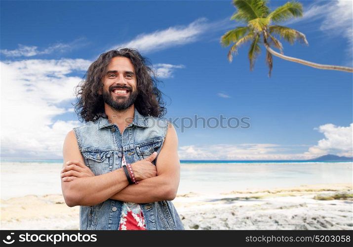 travel, tourism and people concept - smiling young hippie man in denim vest over tropical beach background. smiling hippie man in denim vest on summer beach