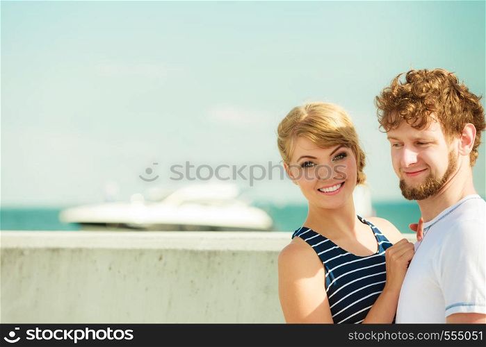 Travel tourism and people concept. Young tourist couple on vacation standing in front of boats sea water